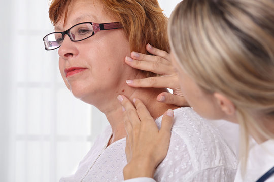 Doctor dermatologist examines birthmark of senior woman. Checking benign moles. Laser Skin tags removal