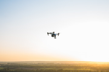 Fototapeta na wymiar White drone, quadrocopter with photo camera flying in the blue sky.