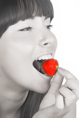 brunette girl eating a strawberry