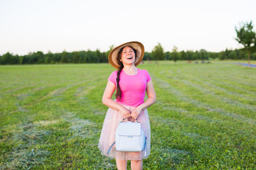 Fototapeta premium Young woman with blue backpack and hat on nature