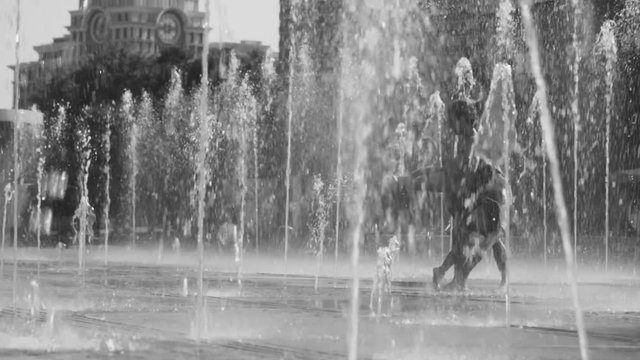 Young happy couple standing in the fountain