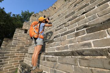 young woman photographer taking photo on great wall