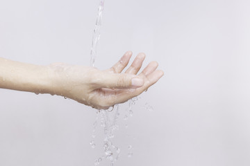 The Asian girl's hands are splashed with water on white background