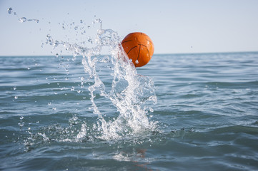 orange water polo ball on blue water background