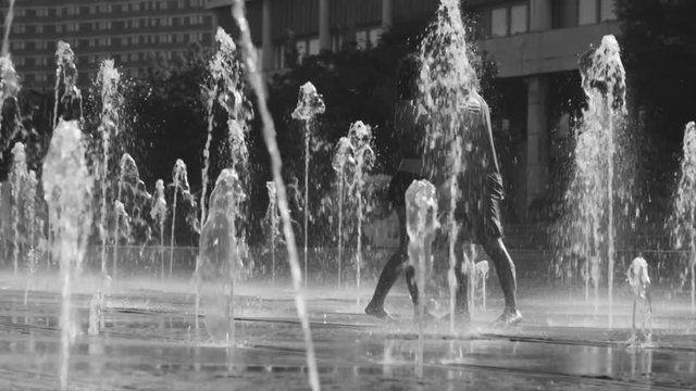 Young happy couple dancing in the fountain