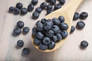 CloseUp Of Fresh Blueberries on a wooden spoon