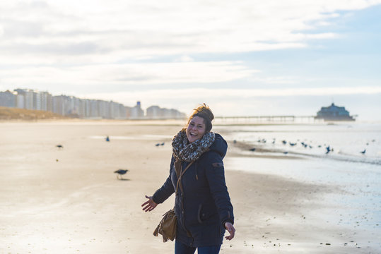 Gl&uuml;ckliche Frau im Gegenlicht am Strand von Blankenberge in Belgien