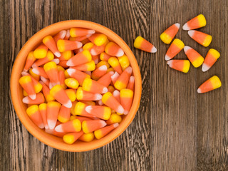 Delicious Fall/Halloween Themed Candy Corn in a Bowl on a Decorative Wooden Background