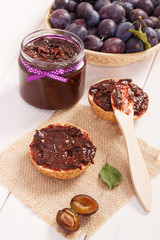 Knife, sandwiches with plum marmalade or jam on jute burlap, preparation breakfast concept