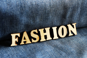 Wooden letters and jeans, the word fashion.

