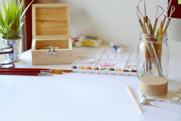 Artist workplace : White table of an artist with art tools for drawing.