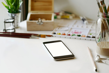 Artist workplace : White table of an artist with art tools for drawing.