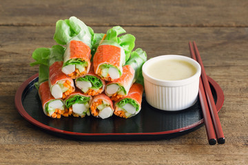 Fresh spring rolls with fresh vegetable and crab stick served with wasabi mixed salad cream dipping sauce. Rolls salad or fresh spring roll in Japanese style, healthy tasty food for appetizer or meal.