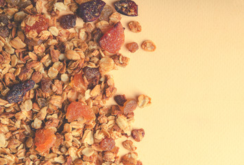 Homemade granola with honey, oatmeal, nuts, raisin, cranberry and dried apricots. Top view, toned with copy space