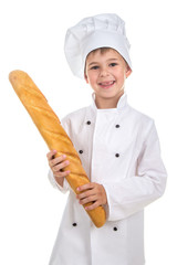 Little funny boy dressed in chef uniform with fresh baguette.