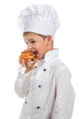 Little cute chef cooker eating delicious fresh raisin bun, isolated on white