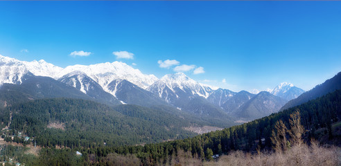 Panoramic view of beautiful mountain landscape small village among snow pine trees mountain background