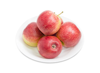 Several red apples on a white dish closeup