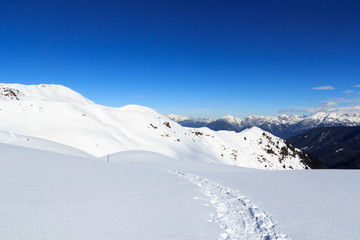 Fototapeta na wymiar Mountain panorama with snow and snowshoe trail in winter in Stubai Alps, Austria