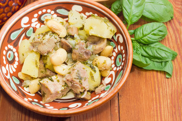 Roasted potatoes with meat, mushrooms and beans closeup