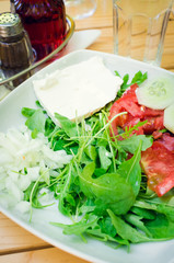 Fresh salad with feta cheese, tomatoes, cucumber and arugula leaves