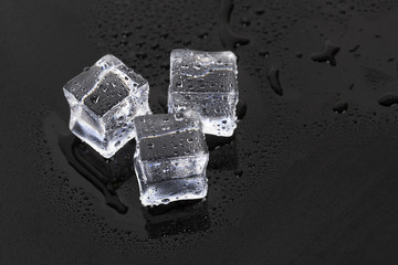 Ice cubes on glass table. On black background.