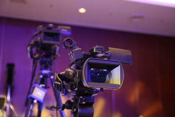 Closeup of  television cameras with blue light in studio.