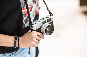 Young hipster woman hand holding retro camera close-up