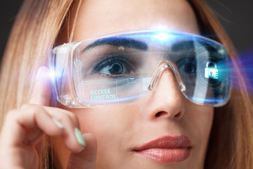 Business, Technology, Internet and network concept. Technology future. Young businesswoman working in virtual glasses, select the icon Access control on the virtual display