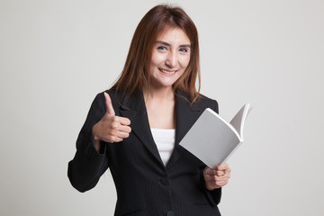 Naklejka premium Young Asian woman thumbs up with a book.