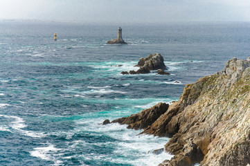 Pointe du Raz, the western point of Finistere, in Brittany, France - cliffs and lighthouse in the Atlantic Ocean