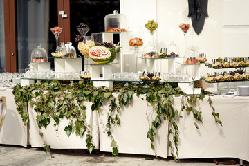 white bar with fruits decorated with green branches hanging from it