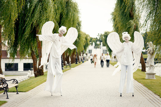 Angels on stilts greet people on the path