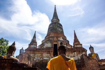 Thai old pagoda and buddha statue with blue sky