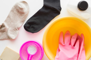 Socks washing with different detergents. Bowl with rubber protective gloves. Dry cleaning concept. Clothes care. Chores of maid. Regular washing.