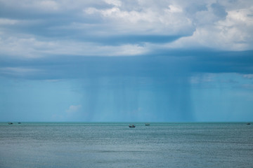 Obraz premium Fishing vessel under storm with big waves in storm and raining..Dark rainy clouds over tropical sea..Sea landscape with bad weather and the cloudy sky.