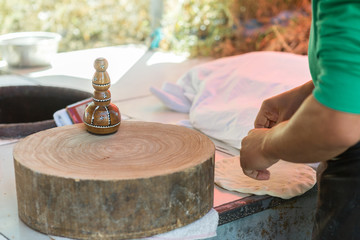 Fototapeta na wymiar Uyghur Men making traditional xinjiang naan bread, China