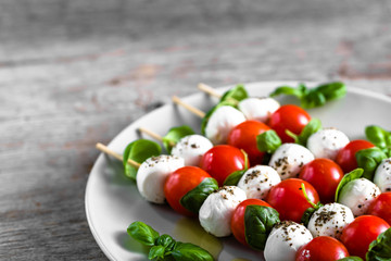 Healthy appetizer - caprese salad with tomato and mozzarella, italian food of mediterranean diet with olive oil dressing, weight loss concept