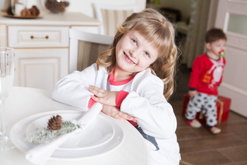 the happy little girl in a pajamas in Christmas morning in kitchen of the home