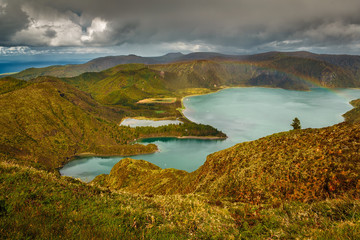 Wide angle view of the Lagoa do Fogo - Lake of Fire - with a rainbow in the island of Sao Miguel, The Azores, Portugal. The archipelago of the Azores is a hidden gem holiday destinations in Europe.