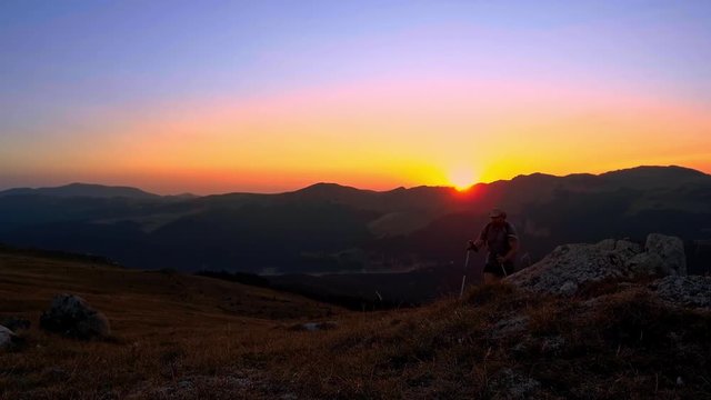 Man hiking at sunset in mountains
