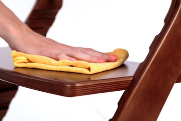 cleaning dust from the furniture by hand with a soft cloth