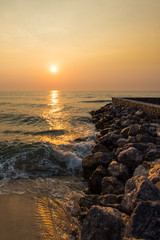 Sunrise over sea and stone coast.