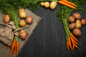 Carrots and potatoes on a black background