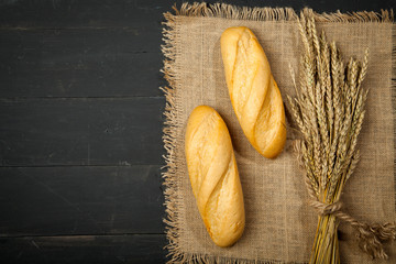 Baguette and wheat on a black background