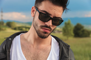 Naklejka na ściany i meble young man in leather jacket and sunglasses posing outdoor