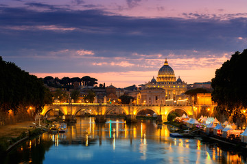 Night view of old Sant' Angelo Bridge  and St. Peter's cathedral in Vatican City Rome Italy.