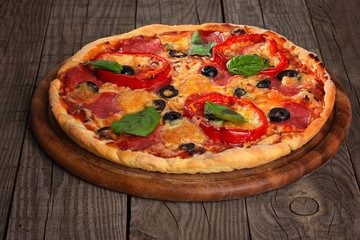 Delicious pizza served on wooden plate 