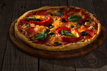 Delicious pizza served on wooden plate 