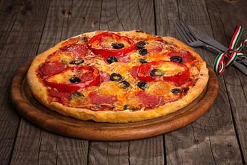 Delicious pizza served on wooden plate 